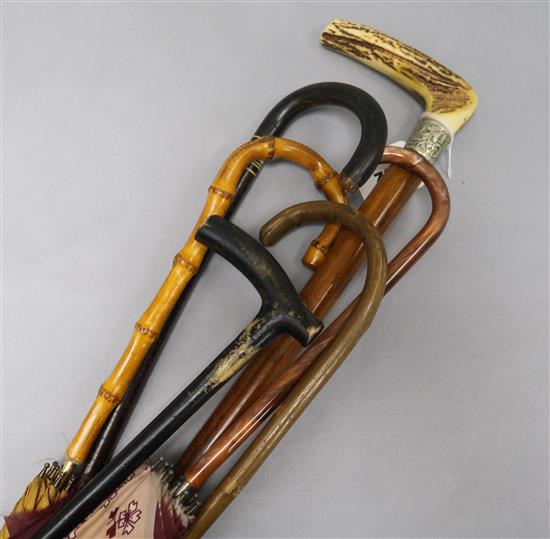 A quantity of walking sticks etc including one silver mounted